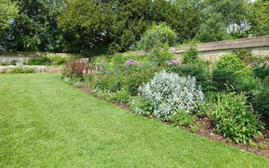Çekici bir İngiliz tarzının manzarası. Geniş bir bahçe. Taze çimenleri biçilmiş.