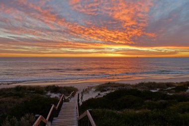 Avustralya 'nın batı kıyısındaki bir sahil ve denizin üzerinde güzel bir günbatımının manzarası
