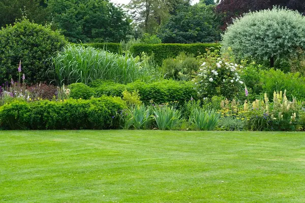 Çekici bir İngiliz tarzının manzarası. Geniş bir bahçe. Taze çimenleri biçilmiş.