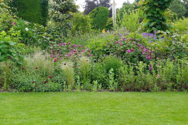 Çekici bir İngiliz tarzının manzarası. Geniş bir bahçe. Taze çimenleri biçilmiş.