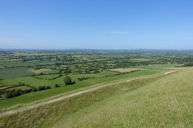 Yeşil tarım arazilerinin manzarası ve yukarıdaki açık mavi gökyüzü yüksek görüş açısına sahip Wiltshire İngiltere 'deki Salisbury Ovası.