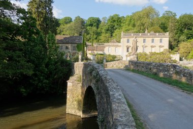Güzel bir İngiliz köyünün nehir kıyısındaki bir yol köprüsünün manzarası - seyahat ve doğa temalı renkli fotoğraf