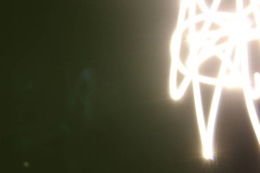 Siyah / yeşil arkaplanda uzun pozlu soyut renkli düzensiz çizgiler. Hafif resim fotoğrafçılığı. Üst üste koymak için düzensiz desenli ışıklar