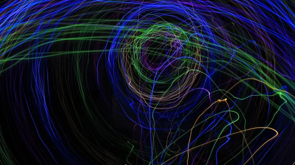 Light painting Abstract colorful irregular lines / patterns on black background with long exposure .