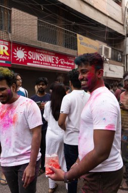 Chennai, Tamilnadu India - 08 Mart 2023: Mint Caddesi, Holi Festival Portresi veya Color Splash Holi kutlamalarında çok sayıda yerli insan tarafından renkli sokak Holi kutlaması