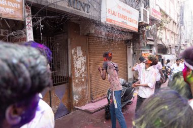 Chennai, Tamilnadu India - 08 Mart 2023: Mint Caddesi, Holi Festival Portresi veya Color Splash Holi kutlamalarında çok sayıda yerli insan tarafından renkli sokak Holi kutlaması