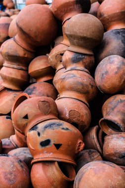 Tencereler boş uzayda bir araya toplanır ve düzenlenir. Çömlekçi, yumuşak renkli kilden yapılmış bir çömlekçi çarkı üzerinde çalışıyor. El ve ekipman ile eski tarz kil kapları.