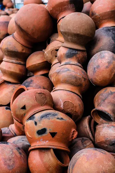 Tencereler boş uzayda bir araya toplanır ve düzenlenir. Çömlekçi, yumuşak renkli kilden yapılmış bir çömlekçi çarkı üzerinde çalışıyor. El ve ekipman ile eski tarz kil kapları.