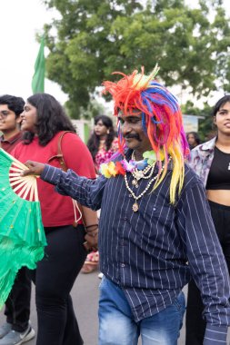 Chennai, Tamilnadu India - 25 Haziran 2023: Gururlu gökkuşağı bayrağı ve bayrağı taşıyan bir grup insanın dikiz görüntüsü.