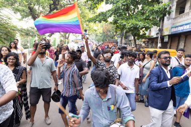 Chennai, Tamilnadu India - 25 Haziran 2023: Gururlu gökkuşağı bayrağı ve bayrağı taşıyan bir grup insanın dikiz görüntüsü.