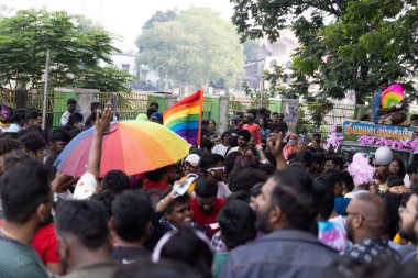 Chennai, Tamilnadu India - 25 Haziran 2023: Gururlu gökkuşağı bayrağı ve bayrağı taşıyan bir grup insanın dikiz görüntüsü.
