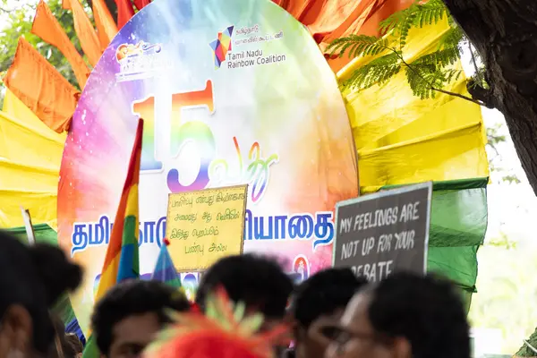 Chennai, Tamilnadu India - 25 Haziran 2023: Gururlu gökkuşağı bayrağı ve bayrağı taşıyan bir grup insanın dikiz görüntüsü.