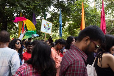 Chennai, Tamilnadu India - 25 Haziran 2023: Gururlu gökkuşağı bayrağı ve bayrağı taşıyan bir grup insanın dikiz görüntüsü.