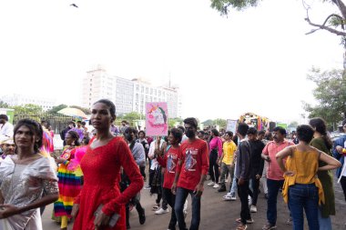 Chennai, Tamilnadu India - 25 Haziran 2023: Gururlu gökkuşağı bayrağı ve bayrağı taşıyan bir grup insanın dikiz görüntüsü.
