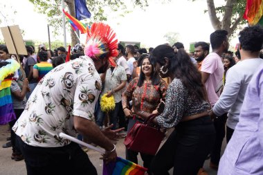 Chennai, Tamilnadu India - 25 Haziran 2023: Gururlu gökkuşağı bayrağı ve bayrağı taşıyan bir grup insanın dikiz görüntüsü.