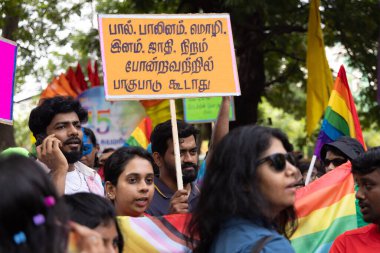 Chennai, Tamilnadu India - 25 Haziran 2023: Gururlu gökkuşağı bayrağı ve bayrağı taşıyan bir grup insanın dikiz görüntüsü.