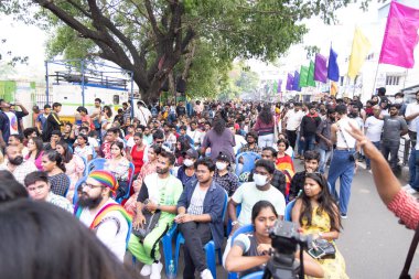 Chennai, Tamilnadu India - 25 Haziran 2023: Gururlu gökkuşağı bayrağı ve bayrağı taşıyan bir grup insanın dikiz görüntüsü.