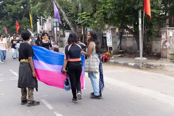 Chennai, Tamilnadu India - 25 Haziran 2023: Gururlu gökkuşağı bayrağı ve bayrağı taşıyan bir grup insanın dikiz görüntüsü.