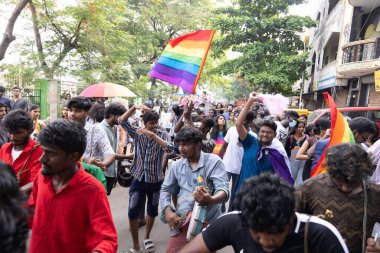 Chennai, Tamilnadu India - 25 Haziran 2023: Gururlu gökkuşağı bayrağı ve bayrağı taşıyan bir grup insanın dikiz görüntüsü.