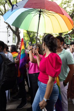 Chennai, Tamilnadu India - 25 Haziran 2023: Gururlu gökkuşağı bayrağı ve bayrağı taşıyan bir grup insanın dikiz görüntüsü.