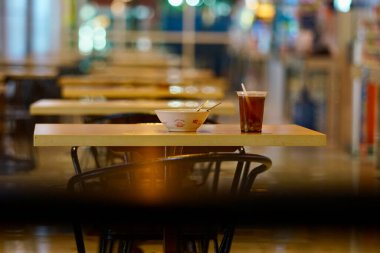 Empty tables viewed as liminal space during the night. clipart