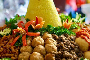 Yan yemekleri (sambal, empal, tempe orek, sambal goreng ati, ve ayam kuning) ile birlikte Nasi Kuning 'in (Aromatik baharatlar ve hindistan cevizi ile Endonezya sarı pirinci) yakın plan görüntüsü. Güneydoğu Asya yemeği.