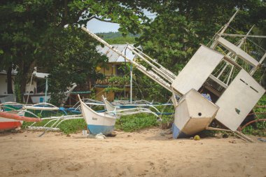 This photo captures the essence of the Philippines, with a traditional wooden boat bobbing on crystal-clear turquoise waters, surrounded by lush green tropical foliage. 