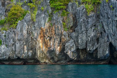 Bu fotoğraf Filipinler 'in şaşırtıcı derecede engebeli kıyı şeridini gösteriyor. Bir dizi kayalık çıkıntılar, dalgalar tarafından pürüzsüz aşınmış, ufukta uzanan, turkuaz deniz çevrelerinde dönerken.