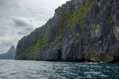 Bu fotoğraf Filipinler 'in şaşırtıcı derecede engebeli kıyı şeridini gösteriyor. Bir dizi kayalık çıkıntılar, dalgalar tarafından pürüzsüz aşınmış, ufukta uzanan, turkuaz deniz çevrelerinde dönerken.