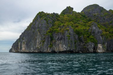 Bu fotoğraf Filipinler 'in şaşırtıcı derecede engebeli kıyı şeridini gösteriyor. Bir dizi kayalık çıkıntılar, dalgalar tarafından pürüzsüz aşınmış, ufukta uzanan, turkuaz deniz çevrelerinde dönerken.