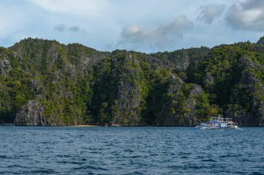 Bu fotoğraf Filipinler 'in şaşırtıcı derecede engebeli kıyı şeridini gösteriyor. Bir dizi kayalık çıkıntılar, dalgalar tarafından pürüzsüz aşınmış, ufukta uzanan, turkuaz deniz çevrelerinde dönerken.