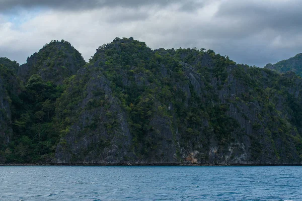 Bu fotoğraf Filipinler 'in şaşırtıcı derecede engebeli kıyı şeridini gösteriyor. Bir dizi kayalık çıkıntılar, dalgalar tarafından pürüzsüz aşınmış, ufukta uzanan, turkuaz deniz çevrelerinde dönerken.