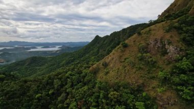 Filipinler Dağları 'nın insansız hava aracı görüntüleri. Sonsuz denizle çevrili güzel yeşil ve sarı dağlar ya da tepeler görebiliriz..