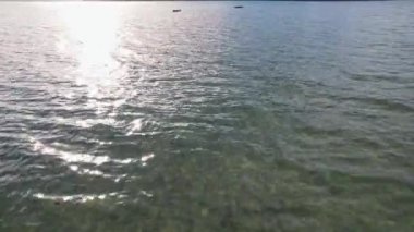 Filipinler 'deki büyük bir adanın sonunda görmek için güneşin yansımalarını taşıyan denizin insansız hava aracı görüntüleri.