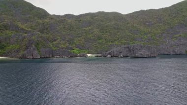 Palawan Filipinleri 'ndeki bir lagünün insansız hava aracı görüntüleri. Etrafımızı saran adayı görmek için 360 yapıyoruz. Gri ve mavi ana renkler..