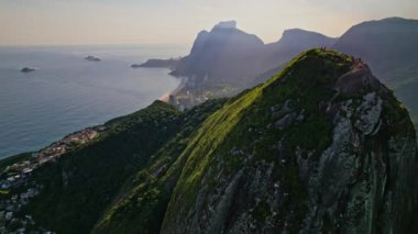 Rio de Janeiro, Brezilya 'da bulunan Dois Irmaos Dağlarının Drone Görüntüleri. Görüntüler, dağları ve kenar mahalleleri görmek için ters doli hareketleriyle başlıyor..