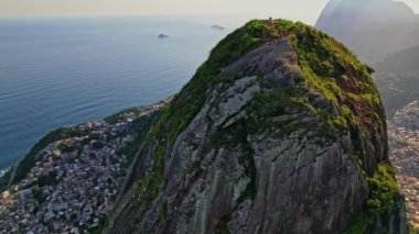 Rio de Janeiro, Brezilya 'da bulunan Dois Irmaos Dağlarının Drone Görüntüleri. Görüntüler gecekondu mahallesi Vidigal 'i ortaya çıkarmak için yörünge hareketiyle başlıyor..