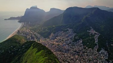 Rio de Janeiro, Brezilya 'da bulunan Dois Irmaos Dağlarının Drone Görüntüleri. Çekimler Dolly Motion ve kuş bakışı dağları ve gecekondu mahallesi Rocinha 'dan sonra başlıyor..