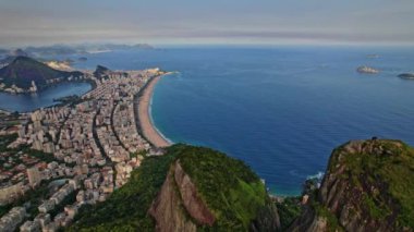 Rio de Janeiro, Brezilya 'da bulunan Dois Irmaos Dağlarının Drone Görüntüleri. Çekimler, Dolly Motion ve daha sonra Rio de Janeiro şehrini ve denizi gösteren bir pan hareketiyle başlıyor..