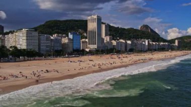 Rio de Janeiro Brezilya 'daki Copacabana Sahili' nin insansız hava aracı görüntüleri. Video, kenarda duran bir bebek olarak başlıyor. Denizi, sahili ve şehri aynı anda görüyoruz..