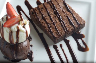 Çikolatalı brownie, çikolatalı ve vanilyalı dondurma, çikolata soslu ve çilekli garnitürlü..