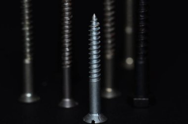 Siyah arka planda izole edilmiş farklı vidaların makro çekimi.