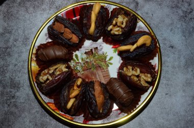 Fındıkla doldurulmuş çeşitli hurmalarla dolu bir süs tabağının yemek fotoğrafı..