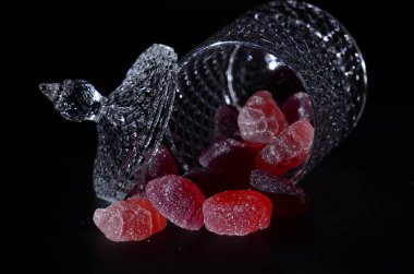  Rengarenk lezzetli şekerlerden oluşan bir yemek sahnesi. Karanlık bir arka plana saçılmış..