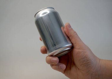 Hand holding plain tin can on a white background