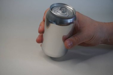 Beyaz arka planda el ele tutuşan gri teneke kutu