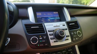 Multimedia head unit on the car's central console, with a large screen and buttons for controlling the automatic air conditioner       