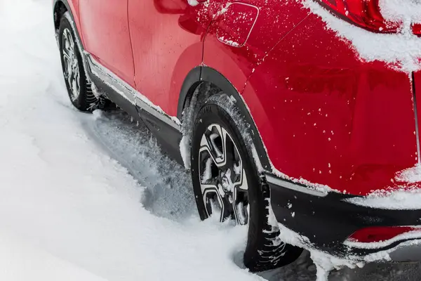 Detail of a car wheel in snowy terrain.