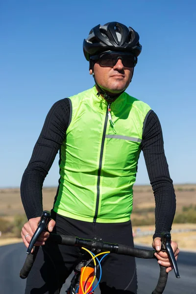 Cyclist riding bicycle on road against clear sky
