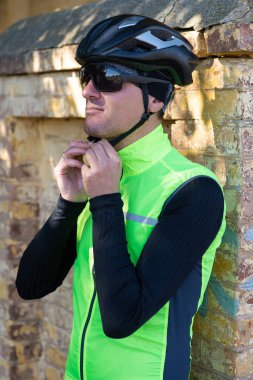 A man in clothes stands with a bicycle on an autumn sunny day. Cyclist in an urban environment.